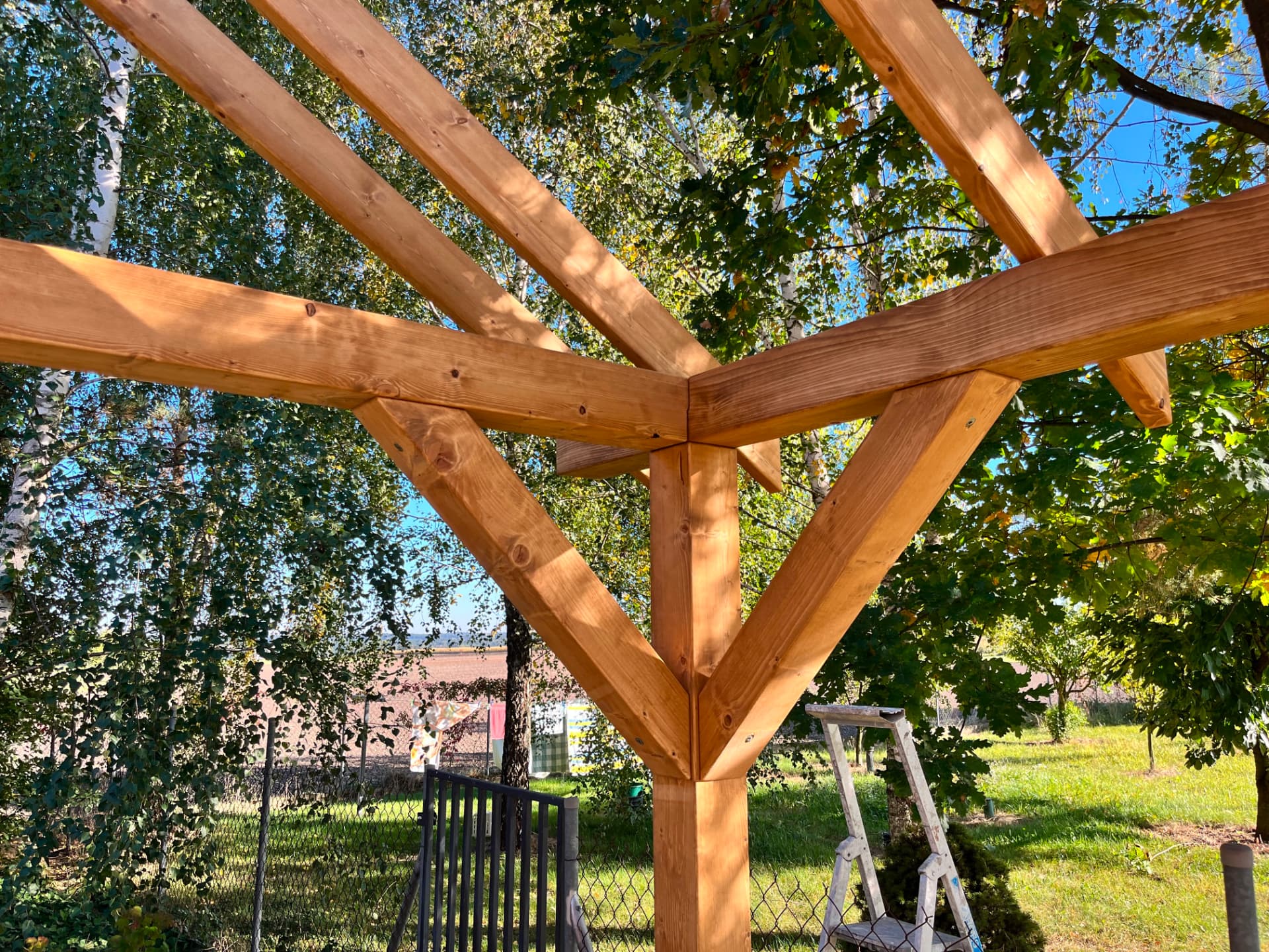 Detal więźby dachowej altany z widocznymi krokwiąmi