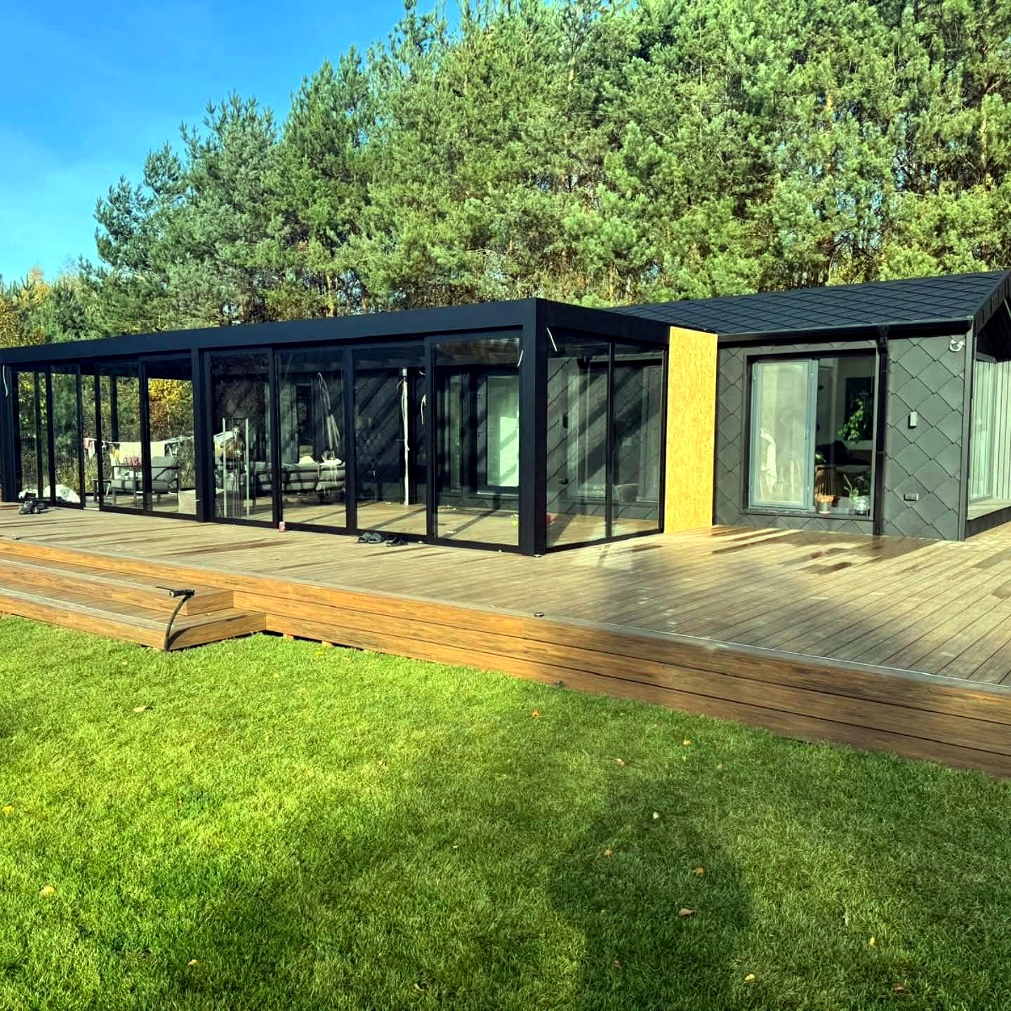 Duży taras kompozytowy przy nowoczesnym domu z ogrodem zimowym — realizacja GoldenWood